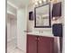 Bathroom with dark wood vanity and floating shelves next to the sink at 3341 Oneida St, Denver, CO 80207