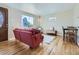 Inviting living room with hardwood floors, a cozy red sofa, and a large window offering natural light at 3341 Oneida St, Denver, CO 80207