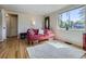Bright living room featuring hardwood floors, a comfortable red sofa, and large windows at 3341 Oneida St, Denver, CO 80207