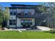 An inviting backyard with a covered patio, second-story deck, stone landscaping, and manicured lawn at 6610 Barnstead Dr, Castle Pines, CO 80108