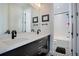 Modern bathroom boasting dual sinks, sleek fixtures, and stylish black-and-white tiled flooring at 6610 Barnstead Dr, Castle Pines, CO 80108