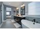Spa-like bathroom boasts a dual sink vanity, a luxurious soaking tub, and stylish fixtures creating a relaxing ambiance at 6610 Barnstead Dr, Castle Pines, CO 80108