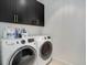 Convenient laundry area with front-loading washer and dryer and upper cabinets at 6610 Barnstead Dr, Castle Pines, CO 80108