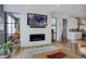 Living room featuring a decorative fireplace, TV, view into the kitchen, and hardwood floors at 6610 Barnstead Dr, Castle Pines, CO 80108