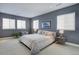 Serene main bedroom with calming colors, plush bedding, stylish lamps, and plenty of natural light from several windows at 6610 Barnstead Dr, Castle Pines, CO 80108