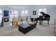 Bright sitting room boasts modern railing, grand piano, comfortable chair, and a stylish black ottoman at 6610 Barnstead Dr, Castle Pines, CO 80108
