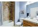 Full bathroom with a tub/shower combo, decorative tile surround, and updated vanity at 15501 E 112Th Ave # 20C, Commerce City, CO 80022
