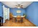 Dining room with hardwood floors, blue walls, a ceiling fan, and a wooden dining table set at 3308 W 11Th Avenue Pl, Broomfield, CO 80020