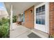 Covered front porch with a seating area, brick accents, and a clear view through the front door at 3308 W 11Th Avenue Pl, Broomfield, CO 80020