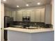 Well-lit kitchen with gray cabinets, stainless appliances, and stone countertops at 11282 Osage N Cir # F, Northglenn, CO 80234
