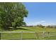 Backyard community space features a large open lawn, trees, community homes, a partial fence and clear skies at 9325 Utica St, Westminster, CO 80031