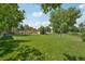 Expansive backyard with lush green grass, mature trees, and a charming fence line for privacy at 9325 Utica St, Westminster, CO 80031