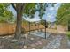 Backyard seating area features a crushed rock landscaping, a pergola with hanging plants, and a privacy fence at 9325 Utica St, Westminster, CO 80031