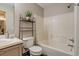 Neutral bathroom featuring a tub-shower combination, light vanity, and shelving at 999 Osceola St, Denver, CO 80204