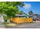 Charming home with a yellow fence, lush tree, and a 