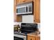 Modern kitchen featuring stainless steel microwave, black glass cooktop and wood cabinets and granite countertops at 1 N Pearl St # 201, Denver, CO 80203