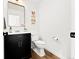 Clean half bathroom with modern fixtures and decor, featuring a black vanity and playful artwork at 11842 Altura St, Commerce City, CO 80603
