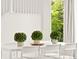 Bright dining area with white table, chairs, and a view of greenery outside the large window at 11842 Altura St, Commerce City, CO 80603