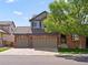 Two-story brick home featuring a tile roof and a two-car garage at 11842 Altura St, Commerce City, CO 80603