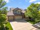 Beautiful two-story brick home featuring a tile roof, manicured lawn, and a three car garage at 11842 Altura St, Commerce City, CO 80603