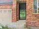Close-up of brick exterior featuring a front door with a glass screen at 11842 Altura St, Commerce City, CO 80603