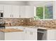Bright kitchen features white cabinets, granite countertops, and tile backsplash at 11842 Altura St, Commerce City, CO 80603