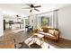 Open concept living room with hardwood floors, adjacent to kitchen with an eat-in dining set at 11842 Altura St, Commerce City, CO 80603