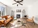 Sunlit living room features a fireplace, stylish furniture, and hardwood floors at 11842 Altura St, Commerce City, CO 80603