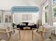Bright living room with a blue sofa, neutral chairs, and large windows with curtains at 11842 Altura St, Commerce City, CO 80603