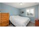 Bedroom with light blue walls, wood dresser and a sunny window overlooking the outdoors at 11805 W 74Th Ave, Arvada, CO 80005