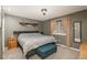 Bedroom with a light gray walls, wooden shelf and nightstand with a blue bench at the foot of the bed at 11805 W 74Th Ave, Arvada, CO 80005