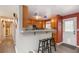 Eat-in kitchen features stainless appliances, tile backsplash, breakfast bar with pendant lighting and two stools at 11805 W 74Th Ave, Arvada, CO 80005