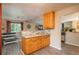 Eat-in kitchen features wood cabinets, breakfast bar with tile backsplash, and wood-look flooring at 11805 W 74Th Ave, Arvada, CO 80005