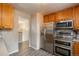 Kitchen showcases stainless steel appliances and wood cabinets with wood-look flooring throughout at 11805 W 74Th Ave, Arvada, CO 80005