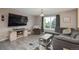 Comfortable living room featuring a sectional sofa, television, and natural light at 11805 W 74Th Ave, Arvada, CO 80005