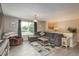 Open living room with gray sofa, gray wood floors, and a view to dining room at 11805 W 74Th Ave, Arvada, CO 80005