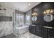 Modern bathroom featuring a soaking tub, glass-enclosed shower, dual vanities, and stylish lighting fixtures at 9407 W Gibraltar Pl, Littleton, CO 80127