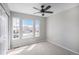 Simple bedroom with carpet, neutral colors, three windows, and a ceiling fan at 9407 W Gibraltar Pl, Littleton, CO 80127
