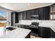 Bright kitchen features dark cabinets, a large island with quartz countertops, and modern stainless steel appliances at 9407 W Gibraltar Pl, Littleton, CO 80127