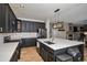 Stylish kitchen with dark cabinets, a large island with quartz countertops, and open layout to other living areas at 9407 W Gibraltar Pl, Littleton, CO 80127