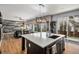 Open-concept kitchen boasts a large island with quartz countertops, a seamless flow into the living space, and wood floors at 9407 W Gibraltar Pl, Littleton, CO 80127