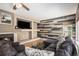 Living room with stone fireplace, a built-in shelving area, and an accent wall made of painted planks at 9407 W Gibraltar Pl, Littleton, CO 80127