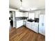 Updated kitchen featuring white cabinets, stainless appliances, a black sink, and hardwood floors at 5343 S Ukraine Way, Aurora, CO 80015