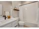 Modern bathroom featuring a shower-tub, white tiled walls, floating wood shelf and a white quartz countertop sink at 1933 W 165Th Way, Broomfield, CO 80023