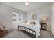 Cozy bedroom with black metal bedframe, large window, round mirror and an accent chair with decorative pillow at 1933 W 165Th Way, Broomfield, CO 80023