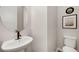 Simple powder room with pedestal sink, round mirror, and tiled floors at 1933 W 165Th Way, Broomfield, CO 80023