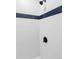 Modern bathroom shower with white tile and a horizontal blue accent stripe at 2340 Jamaica St, Aurora, CO 80010