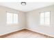 Unfurnished bedroom with hardwood floors, neutral paint and two side windows at 2340 Jamaica St, Aurora, CO 80010