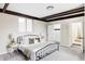 Bright bedroom with exposed beams, neutral décor, carpet, and nearby bathroom at 2340 Jamaica St, Aurora, CO 80010