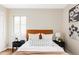 Staged bedroom featuring a padded headboard, side tables and a window at 2340 Jamaica St, Aurora, CO 80010